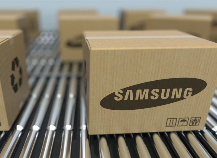 Cardboard boxes with the Samsung logo on them rolling down a conveyor belt.