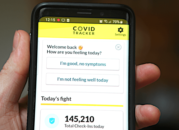 Hand holding a phone with the Covid Tracker Ireland app open.