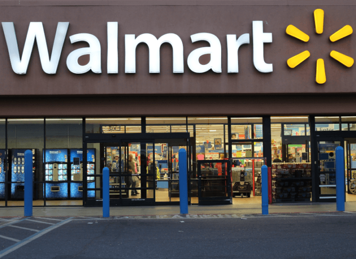 A Walmart retail store, with its white and yellow logo on a wall above the front doors.