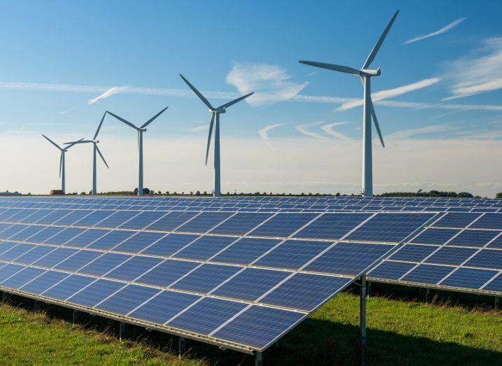 A solar farm and wind turbines on a sunny day.