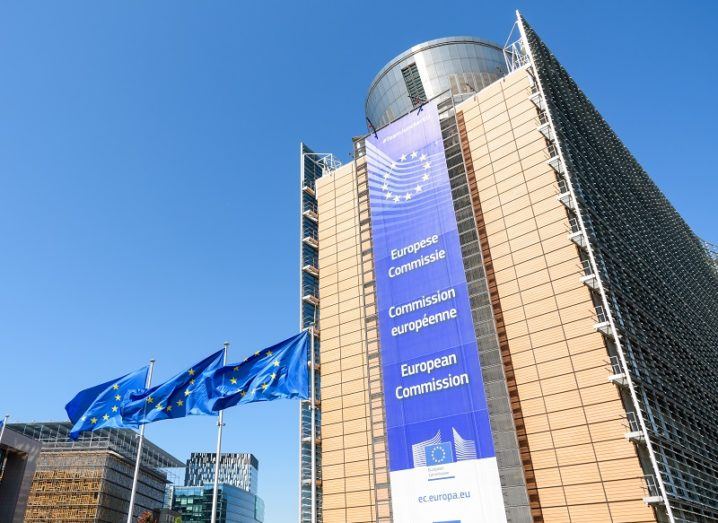 Low-angle view of the European Commission building against a clear, blue sky.