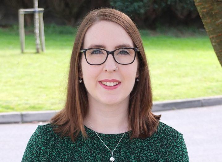 Dr Hannah Durand in a green top against a grass background.