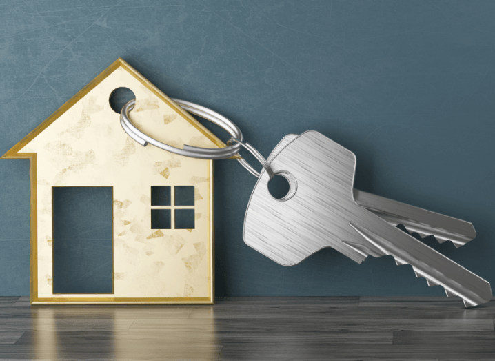 A set of keys beside a house-shaped keyring.