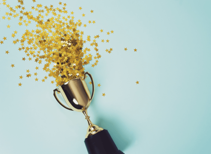 A gold trophy in front of a blue background.