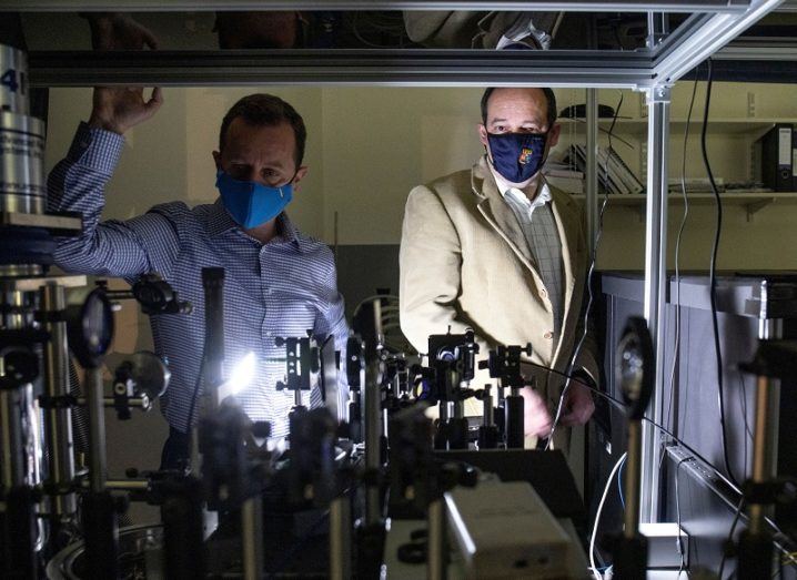 Emanuele Pelucchi and Georgios Fagas wearing face masks surrounded by quantum computer science instruments.