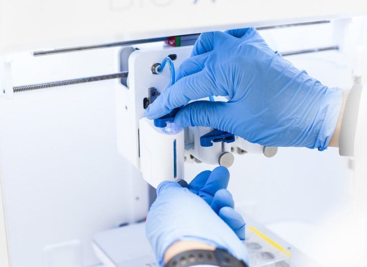 A Cellink 3D bioprinter with an operator wearing blue surgical gloves.