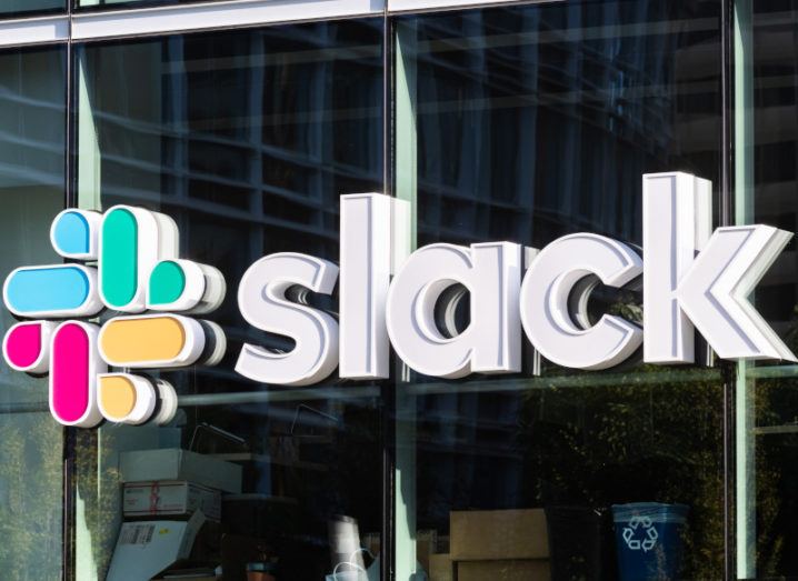 The Slack logo with its colourful hash icon positioned on the large glass panels of an office building.