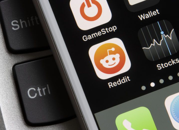 Close-up of phone screen with GameStop, Reddit and Stocks apps on display.