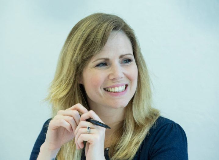 Vicki Reynolds smiling off-camera while holding a pen.