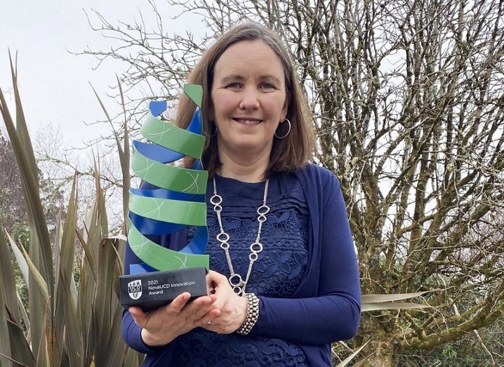 Fiona Doohan stands outdoors with her large blue and green NovaUCD award.