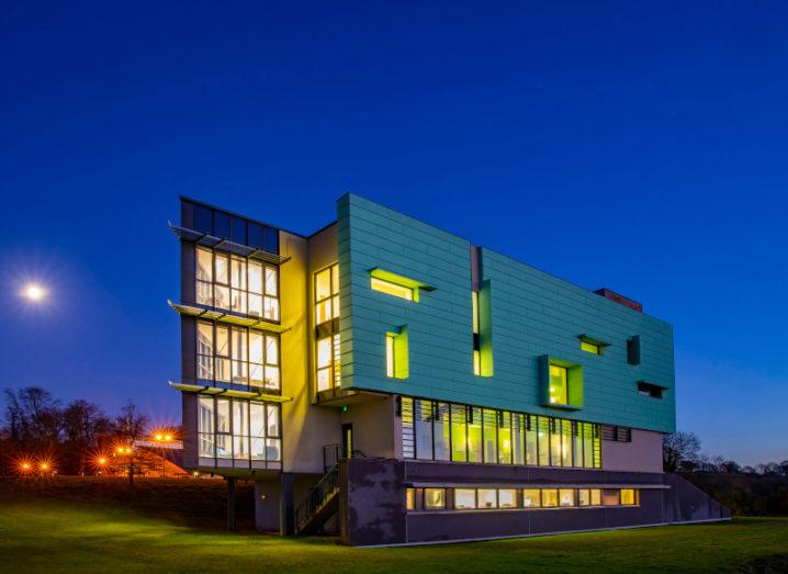 The Walton Institute building is lit up against a dark sky.