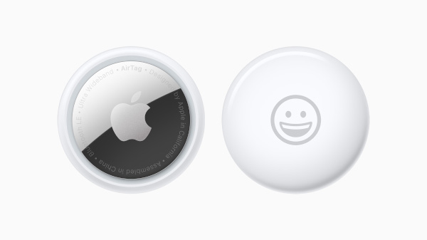 Apple's new AirTag trackers from the front and back.