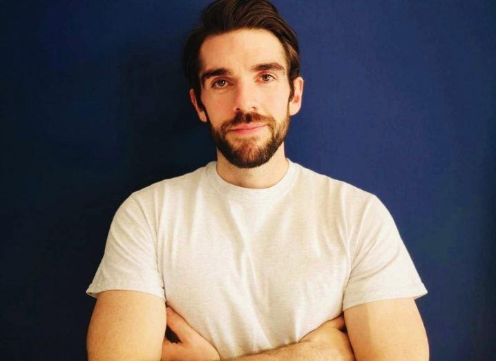 A close-up image of Nori founder Conor Sheridan with his arms folded, standing against a dark wall.