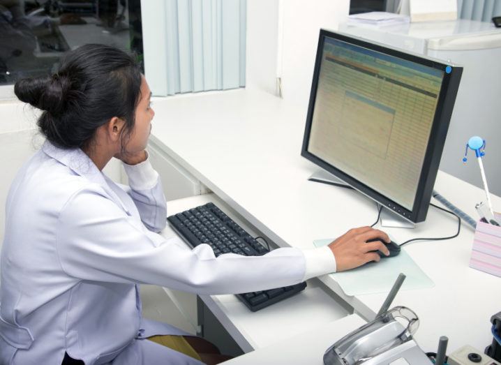 A woman doctor works on a computer in a clinic.
