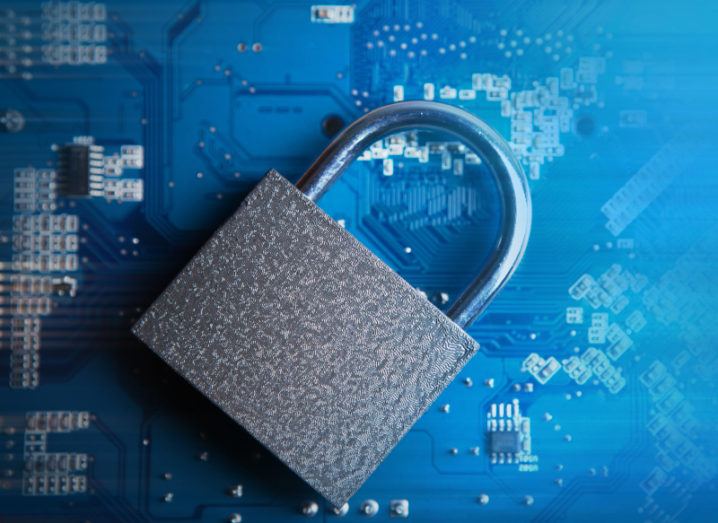 A silver padlock sits on a blue motherboard.