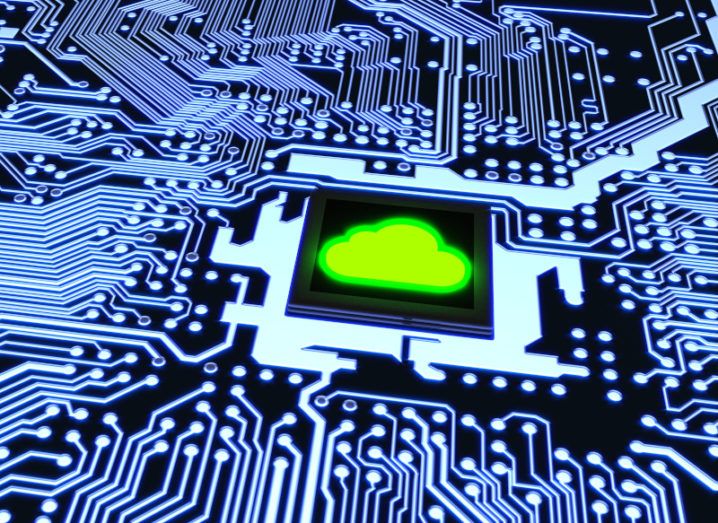 A blue-lit computing circuit board, with a green cloud shape on the microchip at the centre, representing quantum cloud computing.