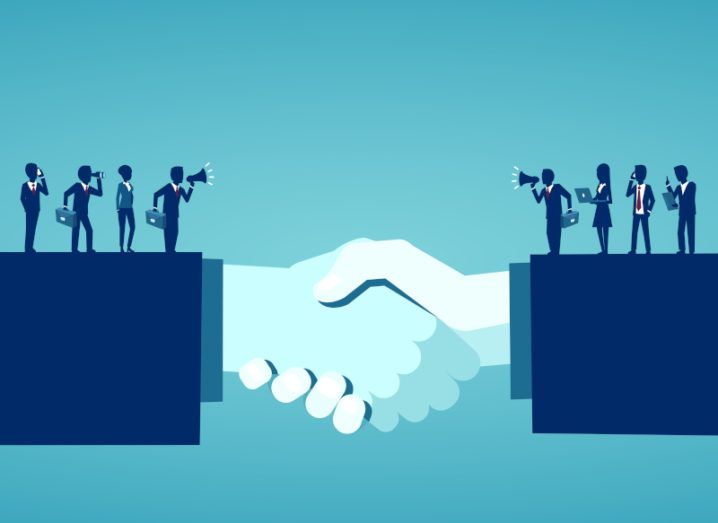 Illustration of hands joined in a handshake, signifying a business deal. Silhouettes of businesspeople holding phones, briefcases and laptops stretch across each arm.