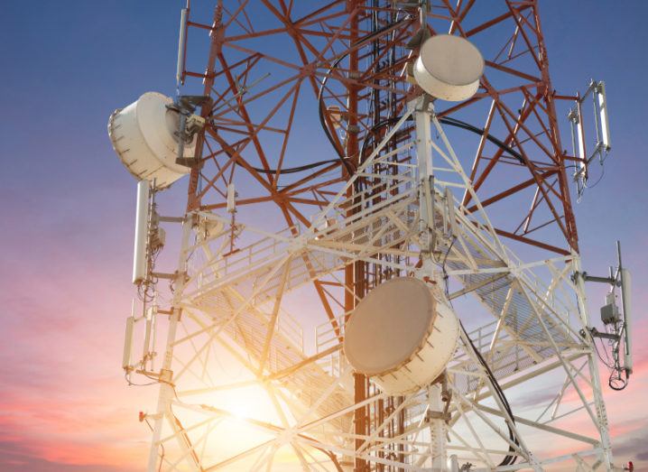 A stock image of a cellular tower against the background of a sunset.