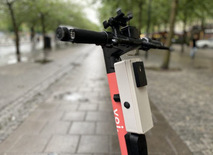 Close-up on the handlebars of a Voi e-scooter with a box affixed to the front containing Luna's computer vision technology.