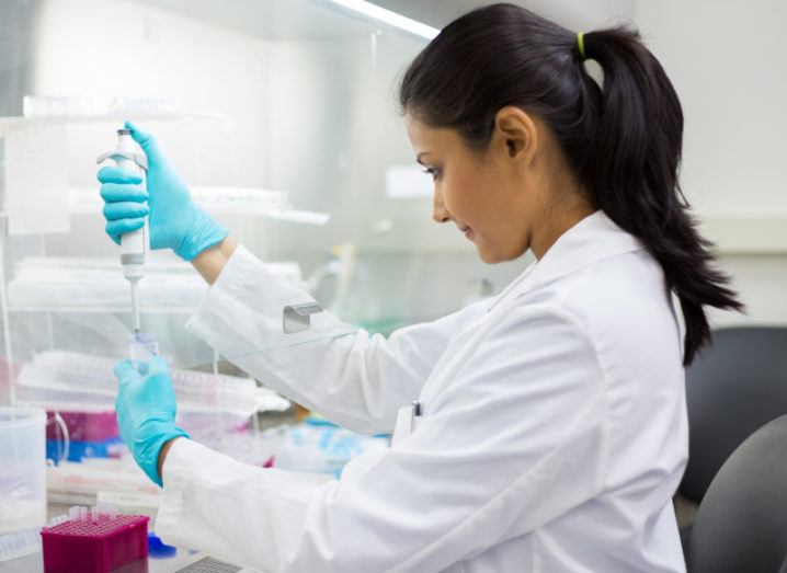 Close-up portrait of a scientist using a pipette in a lab.