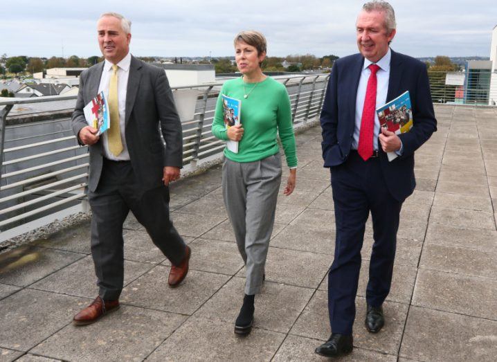 The three presidents of the ITs in Sligo, Letterkenny and Galway and Mayo walking in a row outside carrying brochures.