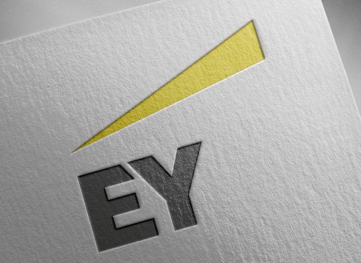 The grey and yellow EY logo embossed on a sheet of paper.