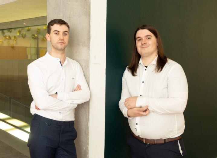 Ignite UCC winners Eoin Buckley and Daniel Keane Kelly standing leaning against a corner of a wall that is dark green on one side and white on the other.