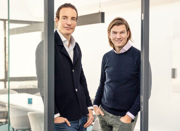 Maximilian Tayenthal and Valentin Stalf of N26 leaning against glass doors in an office building.