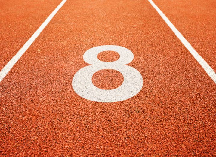 Number eight painted on a brown race track.