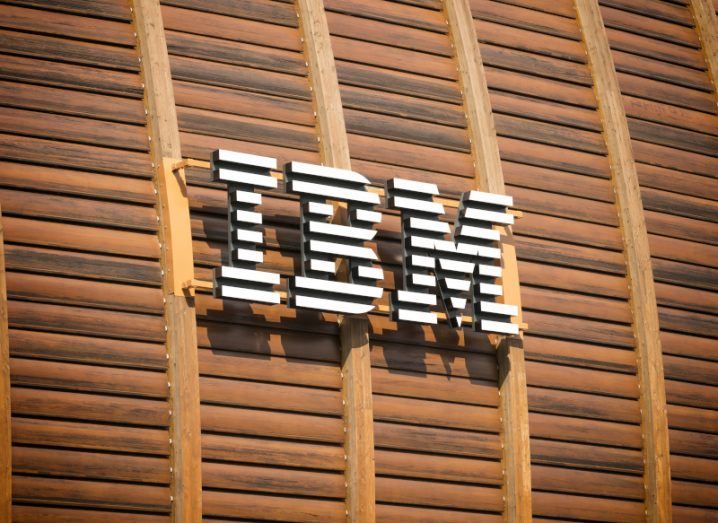 IBM logo in white on a brown wooden background at the IBM Studios building in Milan, Italy.