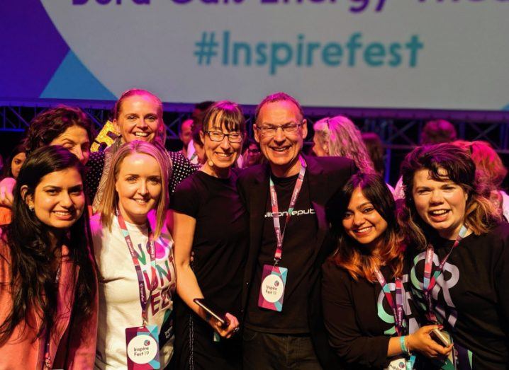 A crowd of people with Ann O’Dea and Darren Mc Auliffe in the centre. They are smiling and wearing Inspirefest 2015 lanyards.