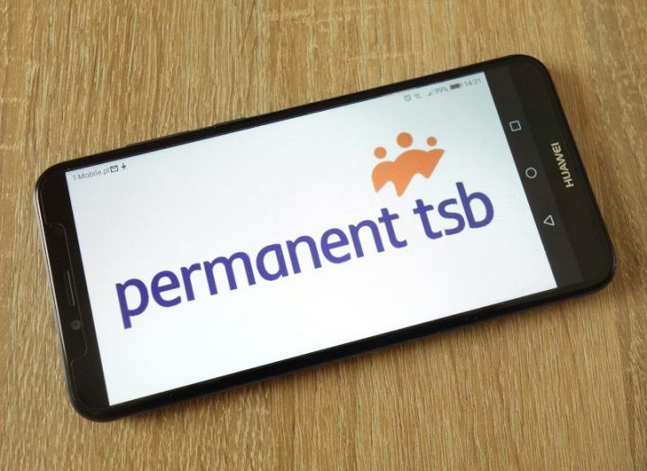 Smartphone showing Permanent TSB logo sitting on wooden surface.