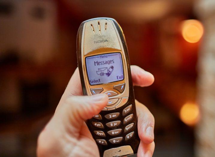 A hand holding up a 2002-era web-enabled Nokia phone.
