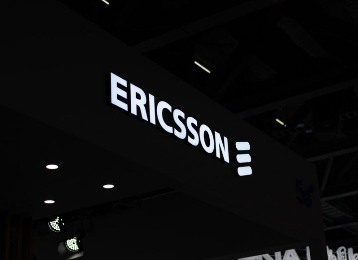 An Ericsson sign lit up against a dark background.