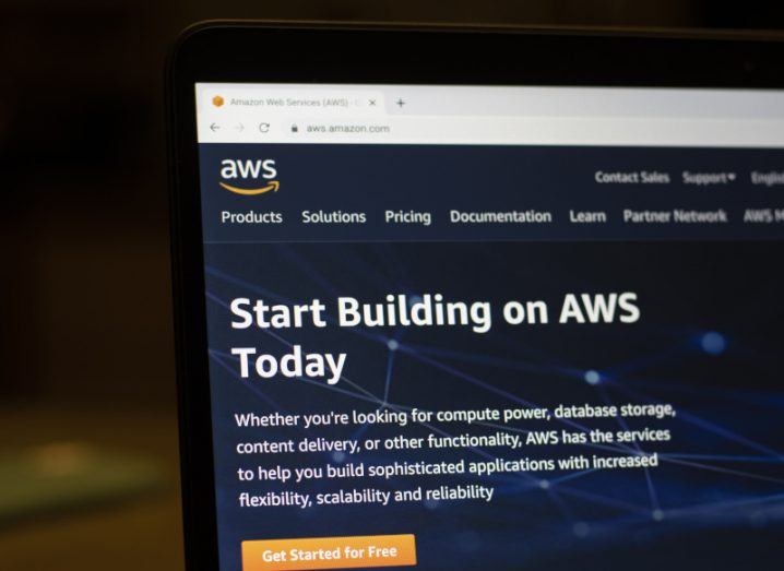 A laptop screen is showing the AWS website, with a page that reads 'Start Building on AWS Today'.