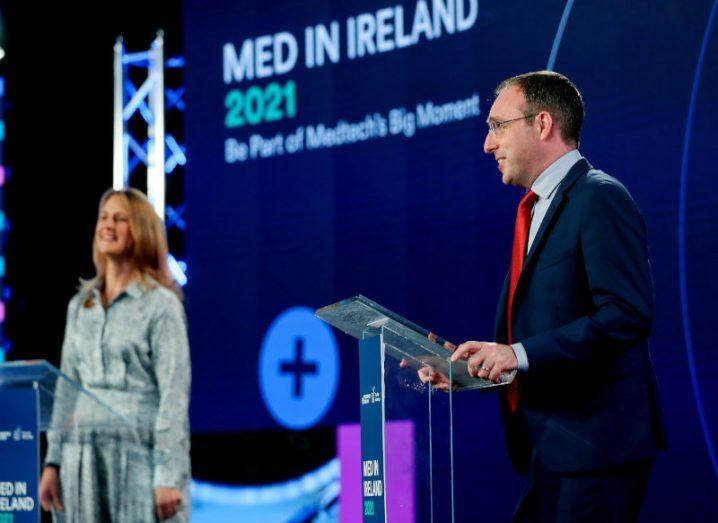 Deirdre Glenn, director of life sciences at Enterprise Ireland and Minister Robert Troy standing at podiums at a conference event.