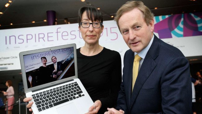Ann O'Dea and Enda Kenny at the Bord Gáis Energy Theathre for Inspirefest 2015. Ann is holding up a Macbook computer with another picture of herself and Kenny on the screen.