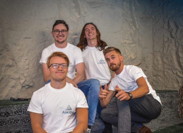 Co-founders Conor Naylor, Tom Nolan, Dan Roberts and Shane Monks O’Byrne seated and posing for the camera wearing white Aikido branded T-shirts.
