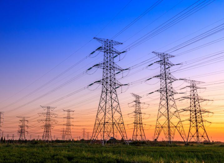 An electricity grid during sunset with blue sky above.