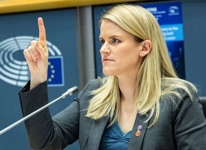 Photo of Frances Haugen with index finger raised, addressing the European Parliament.