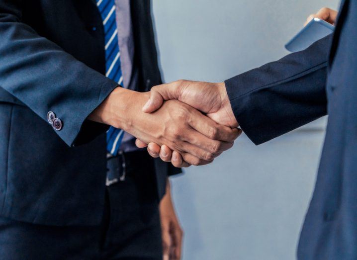 Two male business people shaking hands signifying a deal.