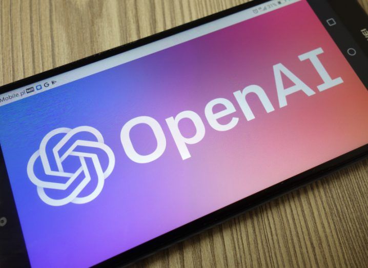 OpenAI logo on a smartphone kept on a wooden table.