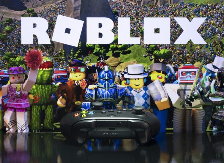 Roblox logo and game on a TV screen with Xbox controller placed in front.