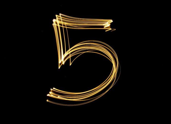 Bright gold lights in the form of thin lines draw the number five against a black background.