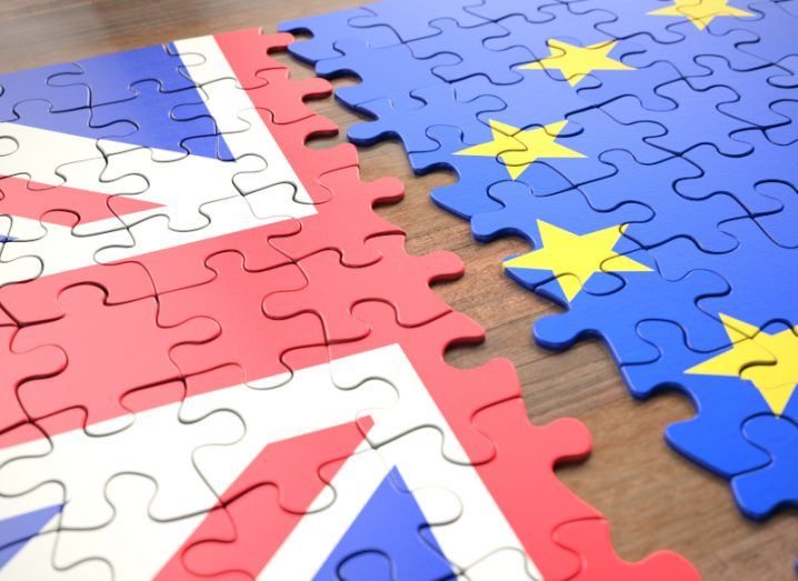 Two puzzles that look like the UK and EU flags next to each other on a wooden table.