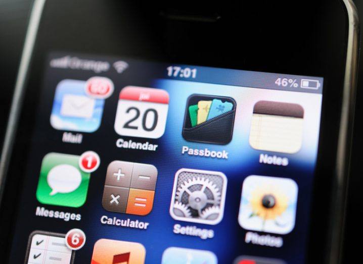 Close-up of a first-generation iPhone screen displaying a series of apps including Passbook, Calendar and Mail.