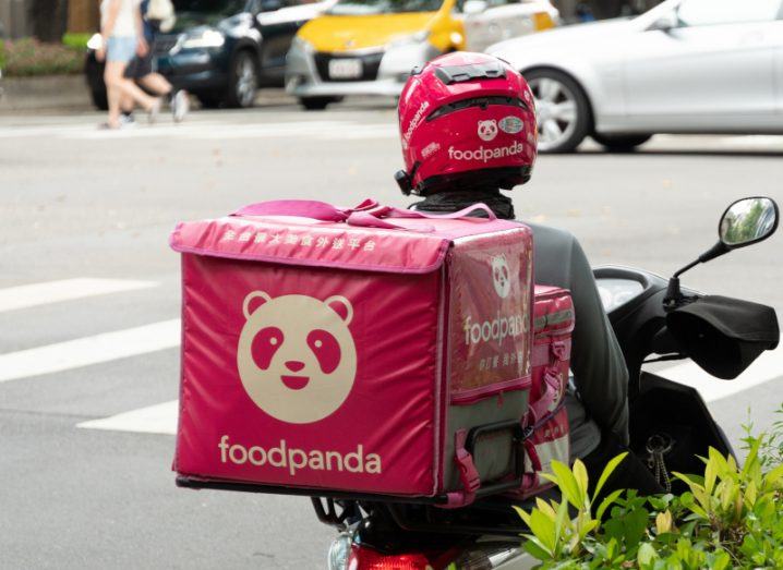 Foodpanda driver on a motorbike with a pink bag with the Foodpanda logo on it.