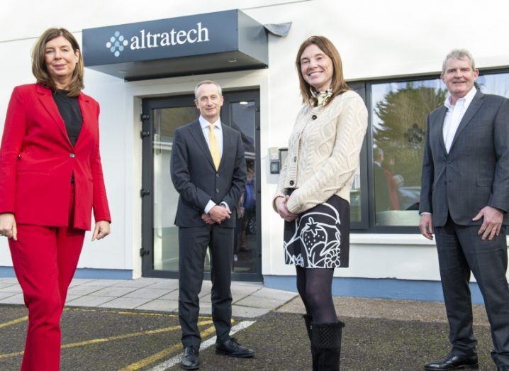 Four people stand outside a building that says 'Altratech' above the door.
