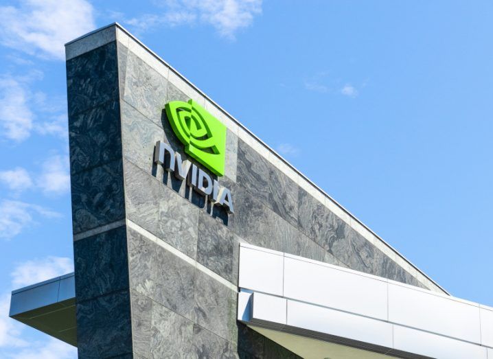 An angled shot of a large grey building with the Nvidia logo on the side against a bright blue sky.