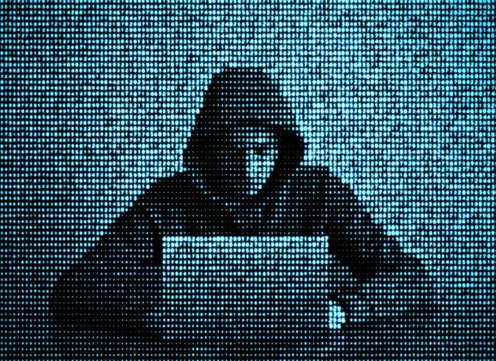 Illustration of a hacker wearing a hoodie in front of a laptop.